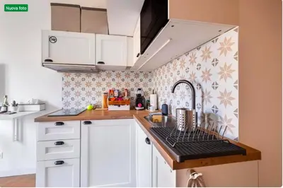 a kitchen with white cabinets and a sink and a stove at The cozy corner of Amelie in Nice