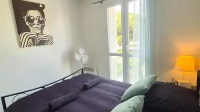 a bedroom with a bed with pillows and a painting at Appartement 2P, balcon, parking proche mer in Nice