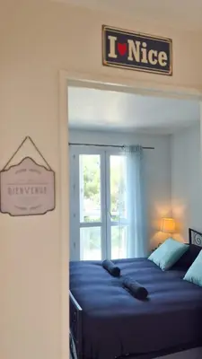 a bedroom with a bed with a nike sign on the wall at Appartement 2P, balcon, parking proche mer in Nice