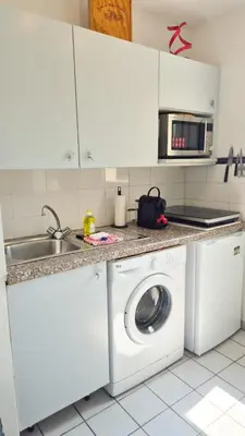 a kitchen with a washing machine and a sink at Appartement 2P, balcon, parking proche mer in Nice