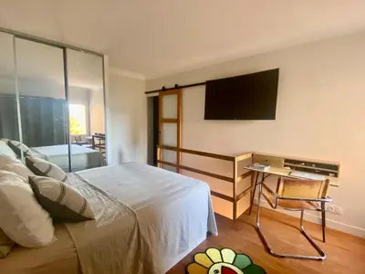 a bedroom with a bed and a desk with a television at Duplex 1 min de la plage in Beaulieu-sur-Mer