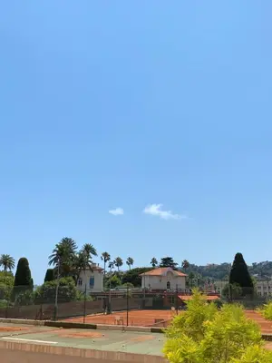 an airplane flying in the sky over a park at Duplex 1 min de la plage in Beaulieu-sur-Mer