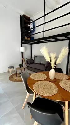 a living room with a table and chairs and a couch at Appartement LOFT in Nice
