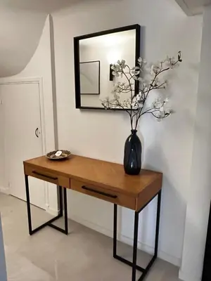 a table with a vase on it with a mirror at Appartement LOFT in Nice