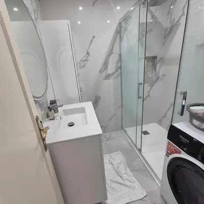 a white bathroom with a sink and a shower at Bahri House in Nice