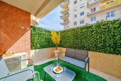 a balcony with a table and a bench and a hedge at Studio Jardin Parking et Clim in Nice