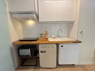 a small kitchen with white cabinets and a sink at ⁂ Charmant Mezzanine Central - Clim Wifi Famille in Nice