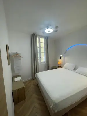 a bedroom with a white bed and a window at Recently renovated apartment in quiet area in heart of Old Nice in Nice