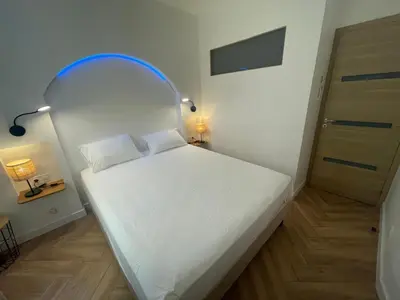 a small bedroom with a white bed with an archway at Recently renovated apartment in quiet area in heart of Old Nice in Nice