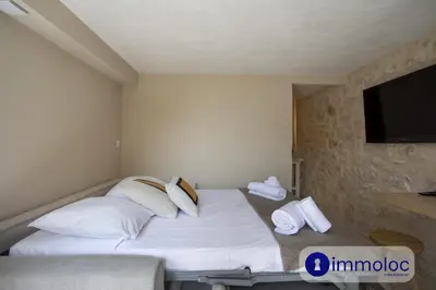 a bedroom with a bed with white pillows and a flat screen tv at Studio in Villefranche in Villefranche-sur-Mer