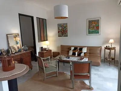 a living room with a couch and a table and chairs at Port de Nice-charmant appartement bucolique ! vue port in Nice
