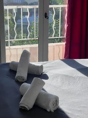 a bed with towels on top of it with a window at Studio à 5min de la plage in Nice
