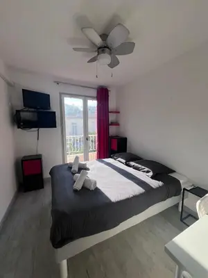 a bedroom with a large bed with a ceiling fan at Studio à 5min de la plage in Nice