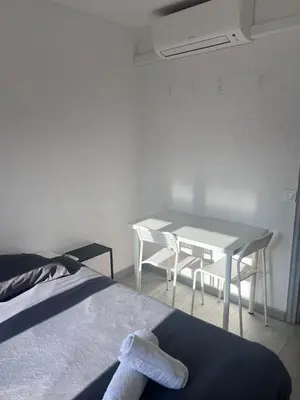 a bedroom with a table and chairs and a bed at Studio à 5min de la plage in Nice