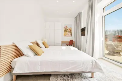 a white bedroom with a large bed and a window at Central Luxurious Property in Antibes
