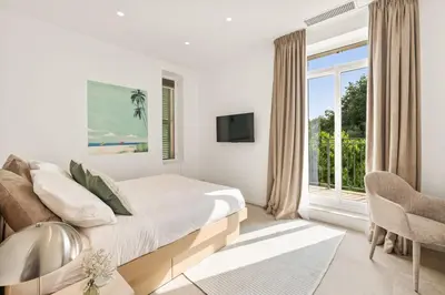 a white bedroom with a bed and a window at Central Luxurious Property in Antibes