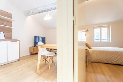 a bedroom with a bed and a desk with a chair at Le Toit d'Azur in Nice