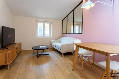 a living room with a table and a couch at Le Toit d'Azur in Nice