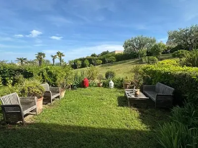 a group of benches sitting in the grass at Spacieux appartement, Jardin, vue mer, calme in Nice