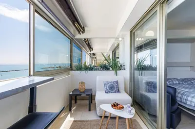 a room with a balcony with a bed and a chair at Sea View- Beach- Chic & Air-Conditioned in Saint-Laurent-du-Var