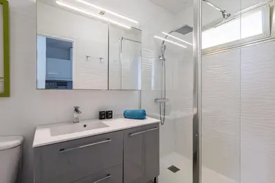 a white bathroom with a sink and a shower at Sea View- Beach- Chic & Air-Conditioned in Saint-Laurent-du-Var