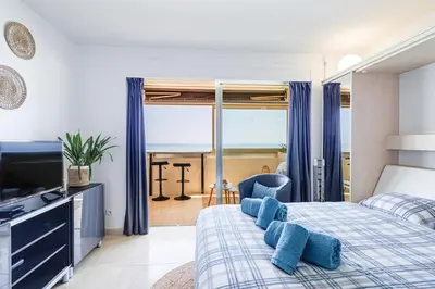 a bedroom with a bed with blue pillows on it at Sea View- Beach- Chic & Air-Conditioned in Saint-Laurent-du-Var
