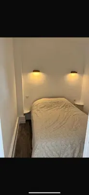 a bedroom with a bed and two lights on the wall at Appartement F2 Nice Ouest in Nice