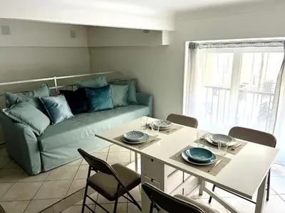 a living room with a table and a couch at Cozy apartement near the beach with with Aircon in Nice