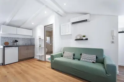 a living room with a green couch and a kitchen at Nice Renting - 6B FRANCE - Massena beach design AC quiet center wifi in Nice