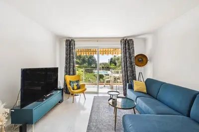 a living room with a blue couch and a tv at Happyfew La Suite Nicerama in Nice