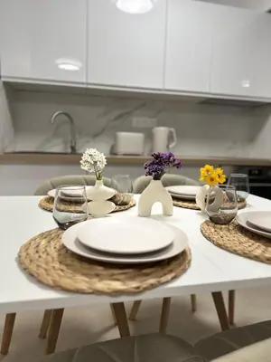 a white table with plates and glasses on it in a kitchen at Sun, beach and relaxation in Cagnes-sur-Mer