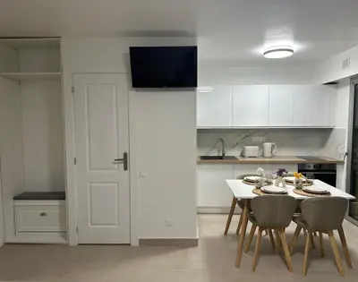 a kitchen with a table and chairs and a white kitchen at Sun, beach and relaxation in Cagnes-sur-Mer