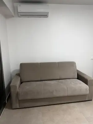 a brown couch in a room with a air conditioner at Sun, beach and relaxation in Cagnes-sur-Mer