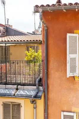 a pipe on the side of a building with a balcony at La Vila-Vielha in Nice