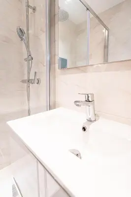 a white bathroom with a sink and a shower at La Vila-Vielha in Nice
