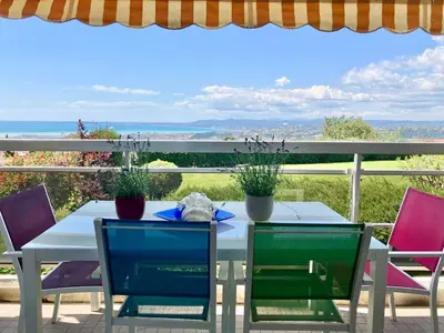 a white table and chairs with a view of the ocean at Quiet Flat with view and Swimming pool in Nice