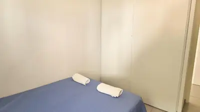 a room with a bed with a blue blanket at T4 avec grande terrasse - BBQ - parking in La Trinité