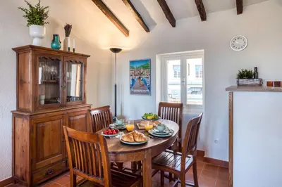 a dining room with a wooden table and chairs at #50 Contesso Duplex -1BDR, Sea View Terrace & AC in Villefranche-sur-Mer