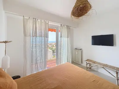 a bedroom with a bed and a large window at Azur in Cagnes-sur-Mer