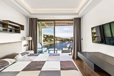 a bedroom with a large bed and a large window at Magnifique appartement avec vue mer époustouflante in Villefranche-sur-Mer