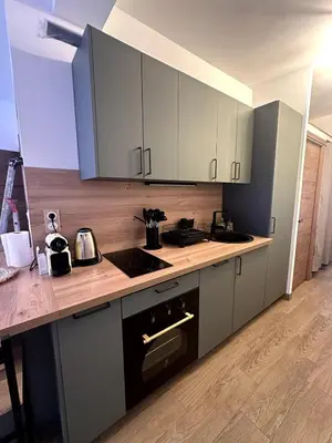 a kitchen with white cabinets and a counter top at F1 Cozy, 150m de la mer in Cagnes-sur-Mer