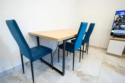 a bedroom with a bed with blue sheets and a chair at Small Paradise 4 Cozy Rooms with AC in Nice