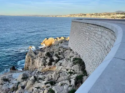 a retaining wall next to a body of water at Perle de Nice - 50 mètres de la plage, Clim, Wifi in Nice