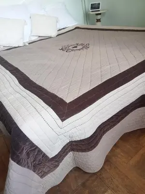 a large bed with a brown and white blanket at Family villa 10 minutes from Nice beaches in Nice