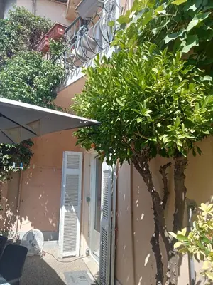 a tree in front of a building with a window at Family villa 10 minutes from Nice beaches in Nice