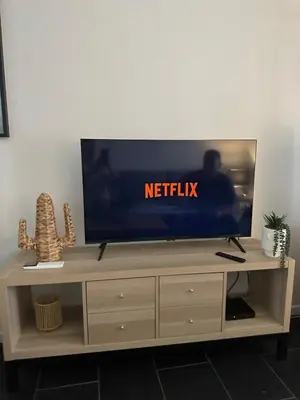 a flat screen tv on top of a wooden entertainment center at Modern and elegant, air-conditioned, city centre - HDP2 in Nice