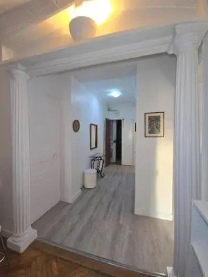 a hallway with white walls and white columns at 2P cosy à 2 min de la mer, Tram aéroport & centre in Nice