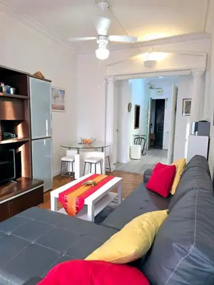 a living room with a couch and a table at 2P cosy à 2 min de la mer, Tram aéroport & centre in Nice