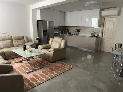 a living room with couches and a table and a kitchen at Cosmina Residence in Nice