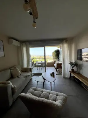 a living room with a couch and a table at Appartement calme vue mer in Saint-Laurent-du-Var